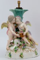 A Meissen style porcelain table lamp base, 19th century. Modelled with two cherubs holding a