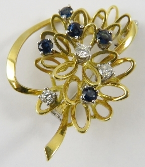 A pretty sapphire and diamond abstract floral brooch, set in yellow and white metals testing as 18ct