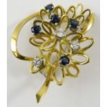 A pretty sapphire and diamond abstract floral brooch, set in yellow and white metals testing as 18ct