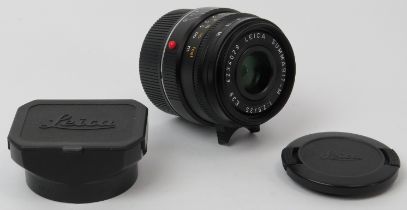 A Leica Summarit-M 1:2.5 / 35mm E39 black camera lens. With caps, hood for 35mm & 50mm f/2.5,