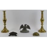 A pair of late Victorian brass candlesticks, two Victorian fire iron rests and a cast lead eagle