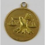 A libra yellow metal pendant, 21.5mm diameter, gross weight 2.5gms. Condition report: some wear to