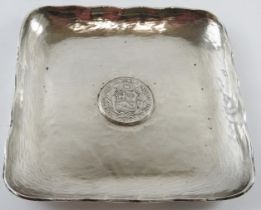 A square planished silver dish with inset Peruvian 1882 9 Decimos coin. 15.5cm x 15.5cm. Marked