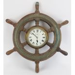 Maritime: A Sestrel bulkhead clock set within an oak and brass six spoke ship’s wheel, 20th century.