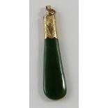 A vintage nephrite and yellow precious metal pendant, the mottled green shaped rectangular pendant