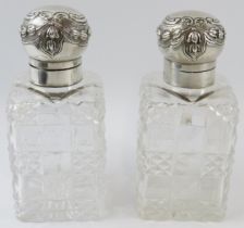 A pair of late Victorian silver mounted cut glass decanter bottles, each with floral swag