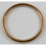 A 9ct rose gold hollow circular bangle tension sprung, 8.5cm external diameter