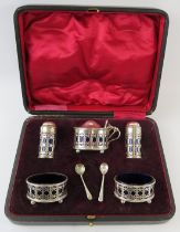 A boxed silver condiment set with blue glass liners. Hallmarked for Birmingham 1919, maker E S