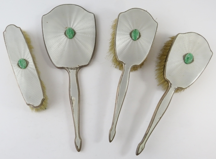 A four piece silver enamelled Art Deco vanity set with green hard stone mounts. Hallmarked for