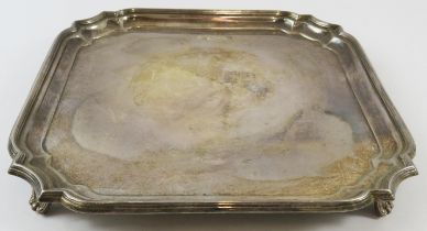 A heavy square form silver salver standing on four feet. Hallmarked for Sheffield 1976, maker Gibson