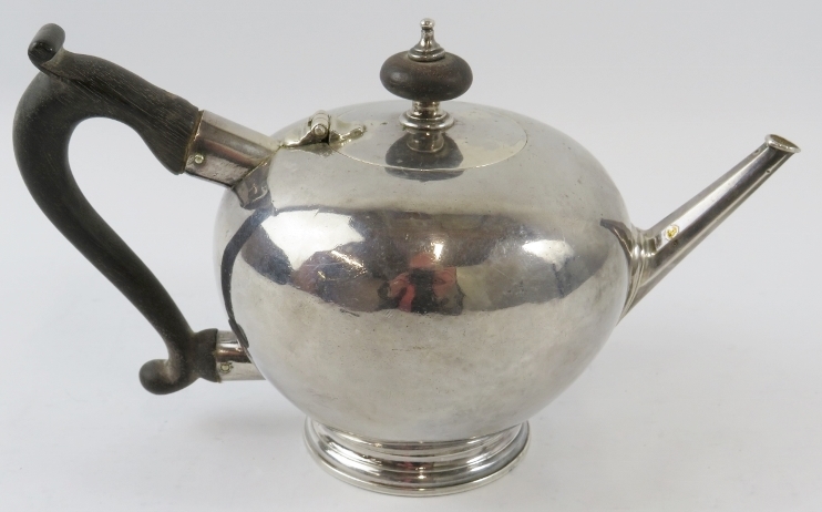 A rare George I silver saffron teapot with bullet form planished body, nonagonal spout and ebony