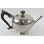 A rare George I silver saffron teapot with bullet form planished body, nonagonal spout and ebony