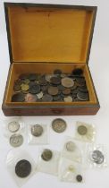 A carved wood box of mixed 19th and 20th century British, European and world coins including a Queen