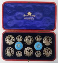 A cased set of late Victorian white metal and enamelled brass buttons. Catchpole and Williams