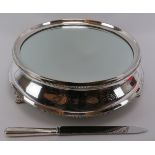 A large silver plated cake stand and cake knife. Cake stand with a glass top, supported on three
