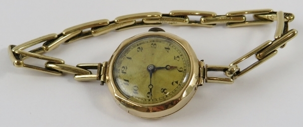 A lady’s 9ct yellow gold wristwatch with round case, fluted bezel, guilloche dial with Arabic