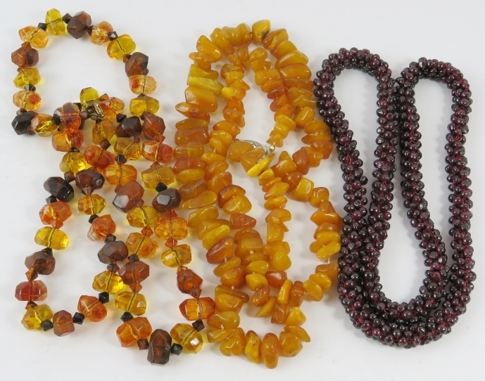 An amber bead long necklace 72cm, another similar, and another necklace with garnet beads, gross