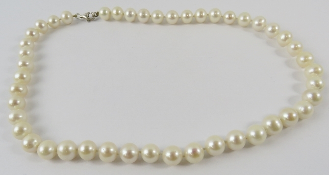 A cultured pearl necklace, the 9-9.5mm ovoid cultured pearls individually knotted with silver clasp,