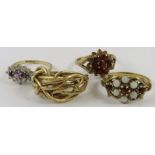 Four 9ct yellow gold rings, variously set with opals, garnets, amethyst and one wirework, gross