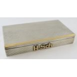 A silver and gold cigarette box with reeded finish and monogram mount. Cedar lined. 18.5cm x 10cm.