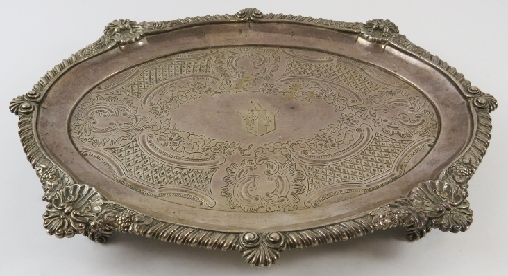 An ornate George III oval silver salver standing on four foliate feet and having a gadrooned, - Image 2 of 4