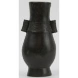 A Chinese bronze twin handled arrow vase, Qing dynasty. Of pear shaped form, cast with hollow