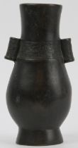 A Chinese bronze twin handled arrow vase, Qing dynasty. Of pear shaped form, cast with hollow