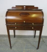 An Edwardian mahogany cylinder writing desk strung with boxwood, the lid opening onto a fitted