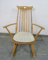 A mid-century blond elm & beech ‘Goldsmiths’ rocking chair by Ercol (model 435) on canted supports