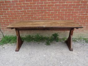 A 19th century Arts & Crafts oak refectory table, the roughly hewn planked top on braced end