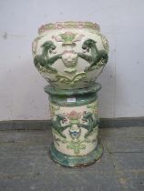 An antique ceramic jardinière on stand in the Classical taste, having relief decoration depicting