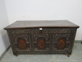 A late 17/early 18th century oak panelled coffer, having internal candle box, the front profusely