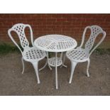 A vintage cast iron 3-piece garden set painted white, comprising a circular two-tier table with