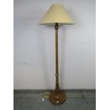 A vintage walnut standard lamp, the tapering fluted and carved column on a circular plinth base with