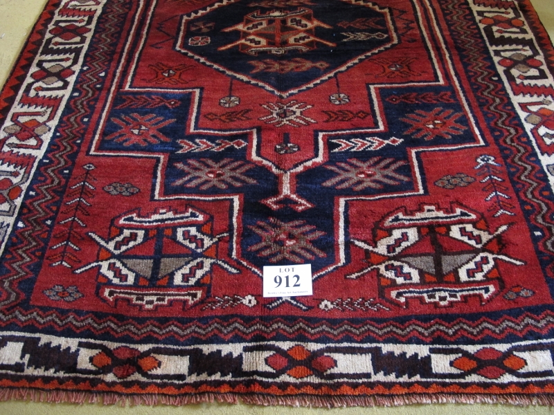 South West Persian Lori rug. Central six sided motif, blue on mellow red ground, geometric pattern