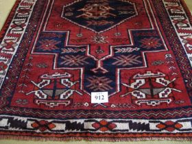 South West Persian Lori rug. Central six sided motif, blue on mellow red ground, geometric pattern