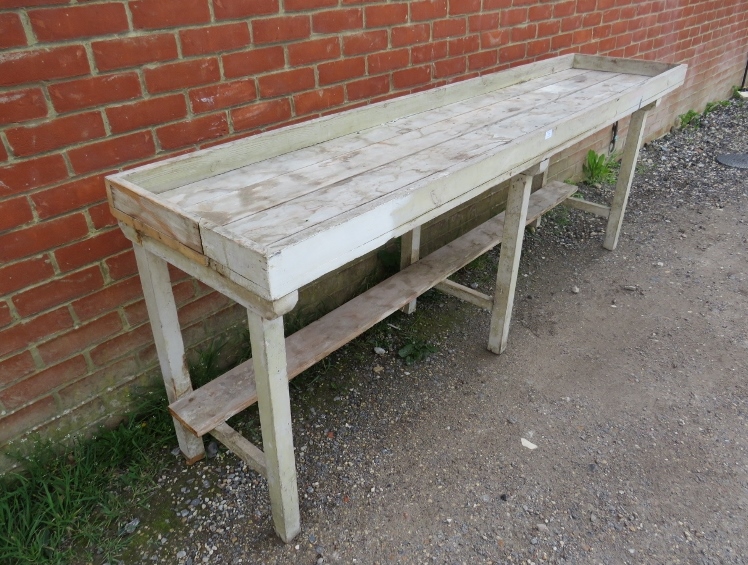 An antique pine potting bench, the galleried planked top on six square supports with stretchers. - Image 2 of 3