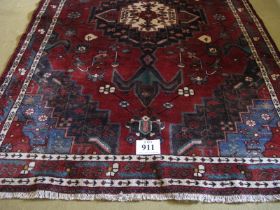South West Persian Afshar rug with a large central motif on red ground highlighted with blue, cream,