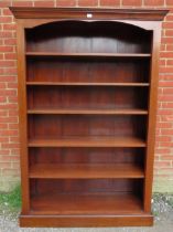 An antique style cherrywood tall open bookcase, the stepped cornice above five height adjustable