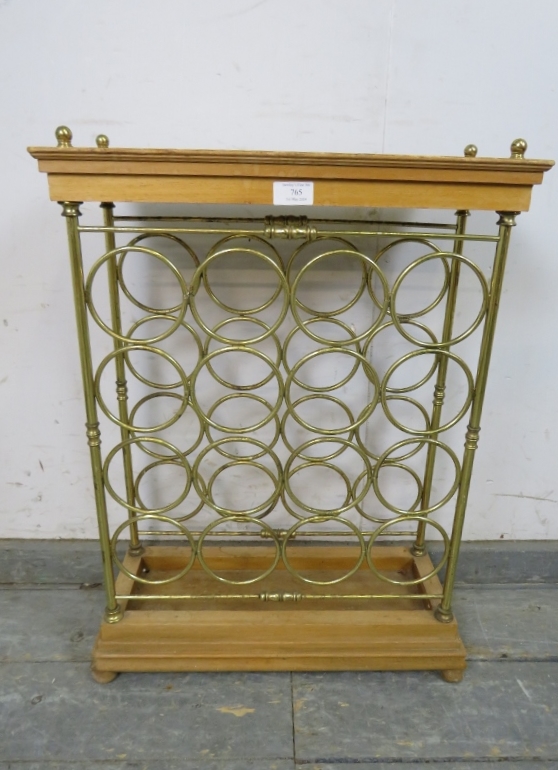A vintage beech and brass wine rack (capacity 16 bottles) with brass ball finials, on a stepped