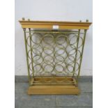A vintage beech and brass wine rack (capacity 16 bottles) with brass ball finials, on a stepped