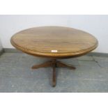 A vintage solid medium oak circular coffee table, on a bulbous turned column with quatreform base.