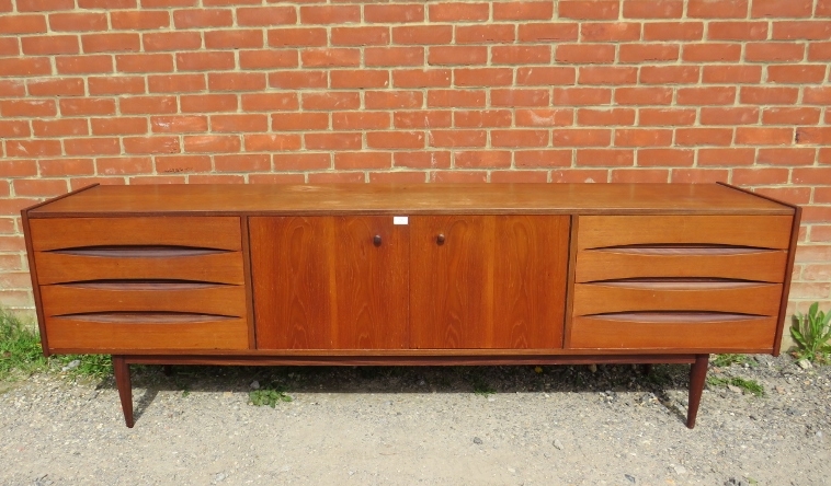 A mid-century Danish teak sideboard, the double doors with turned wooden handles, opening onto a