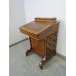 A Victorian figured walnut Davenport, inlaid and crossbanded, the gallery opening onto fitted