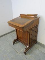 A Victorian figured walnut Davenport, inlaid and crossbanded, the gallery opening onto fitted