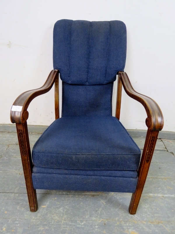 An Art Deco Period walnut open-sided armchair, upholstered in navy material, the shaped and scrolled