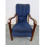 An Art Deco Period walnut open-sided armchair, upholstered in navy material, the shaped and scrolled