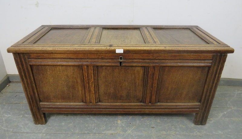 An early 18th century medium oak panelled coffer, retaining the original hinges, on stile