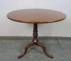 An early Victorian mahogany tilt-top supper table of good colour, on a tapering turned pedestal with