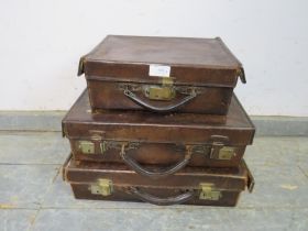 Three graduated antique leather luggage cases of good patina, with brass fittings. Largest H11cm